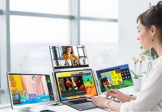 Person using a laptop with multiple displays for different tasks in an office setting.
