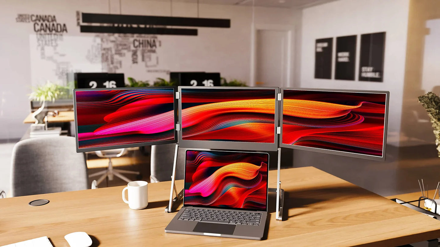 Multimonitor setup on a desk with a laptop in a modern office setting